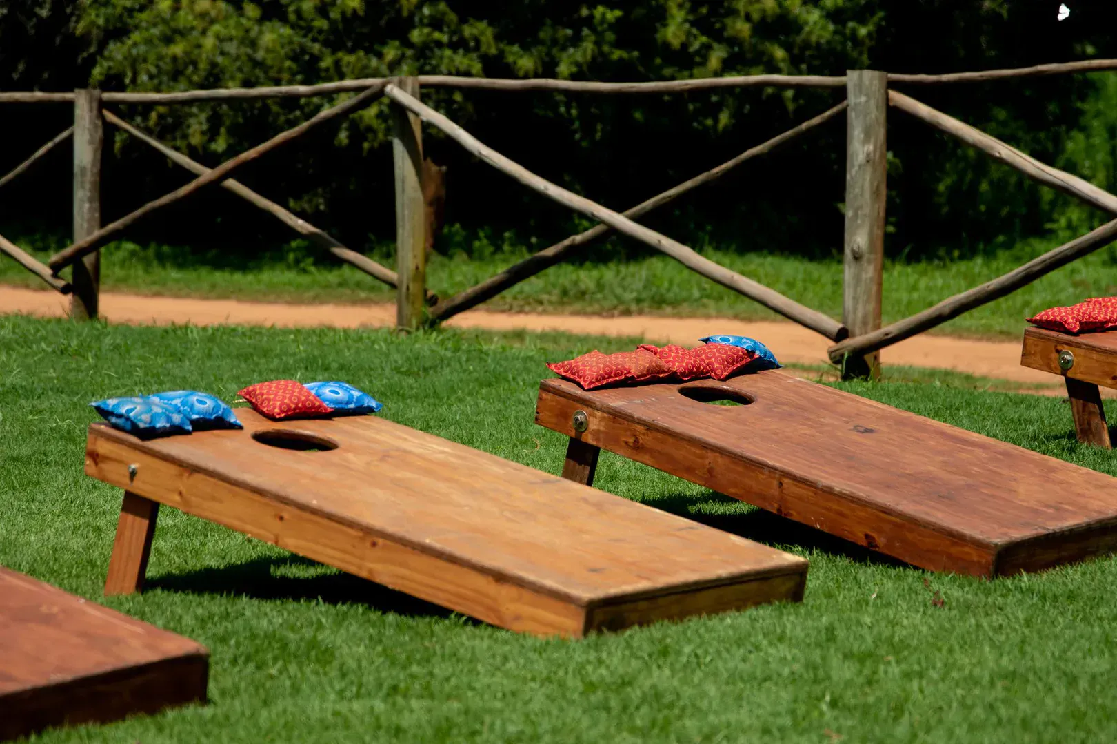 Two regulation 2x4 cornhole boards set up 27 feet apart on a green lawn at a backyard cookout, the kind of setup that makes the best cornhole boards