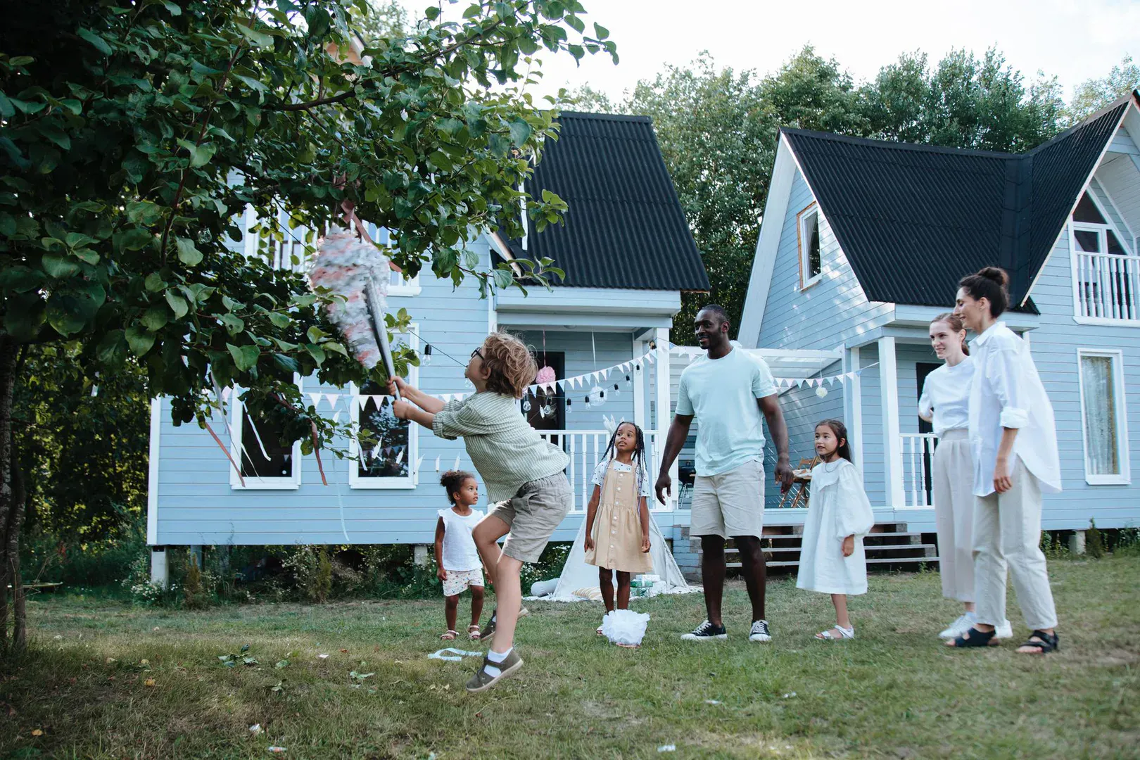 A spread of natural hardwood lawn games on a green lawn including cornhole and kubb blocks, the kind of heirloom gear you want from the best wooden lawn games