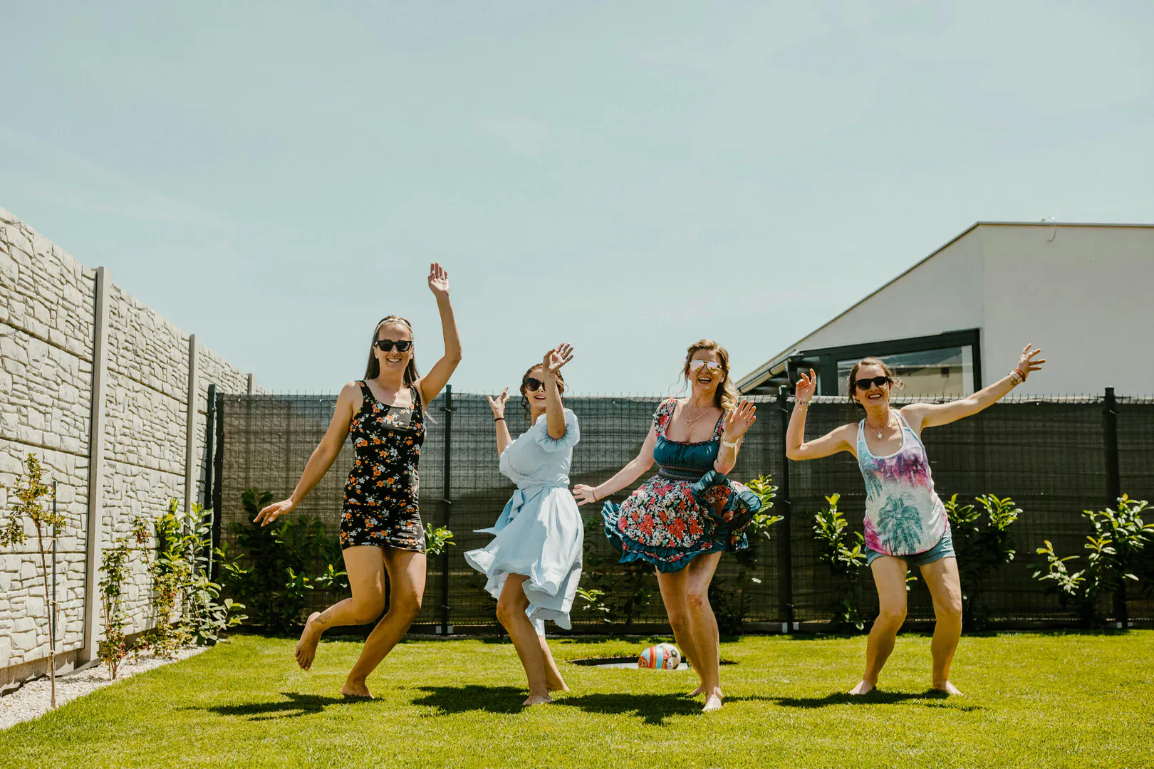 Friends celebrating outdoors at a sunny backyard graduation party