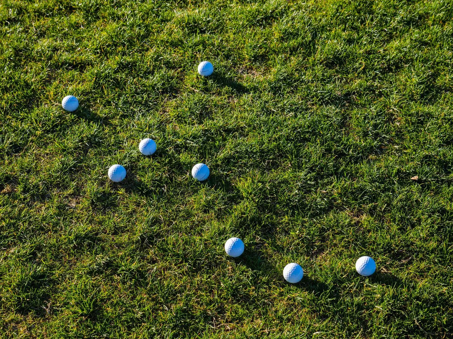 Hands wiping down a colorful resin bocce ball with a soft cloth on a wooden table