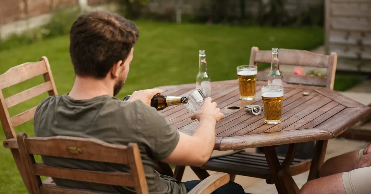 Adults playing the best lawn games for adults, a relaxed round of bocce and cornhole on a well-kept backyard lawn